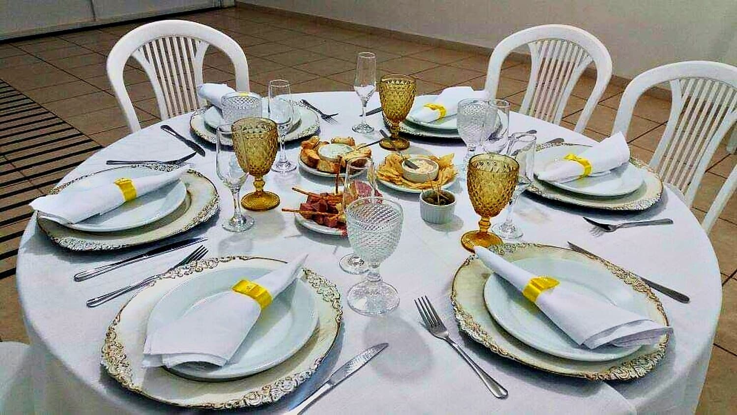 Mesa posta com louça, taças e guardanapos
