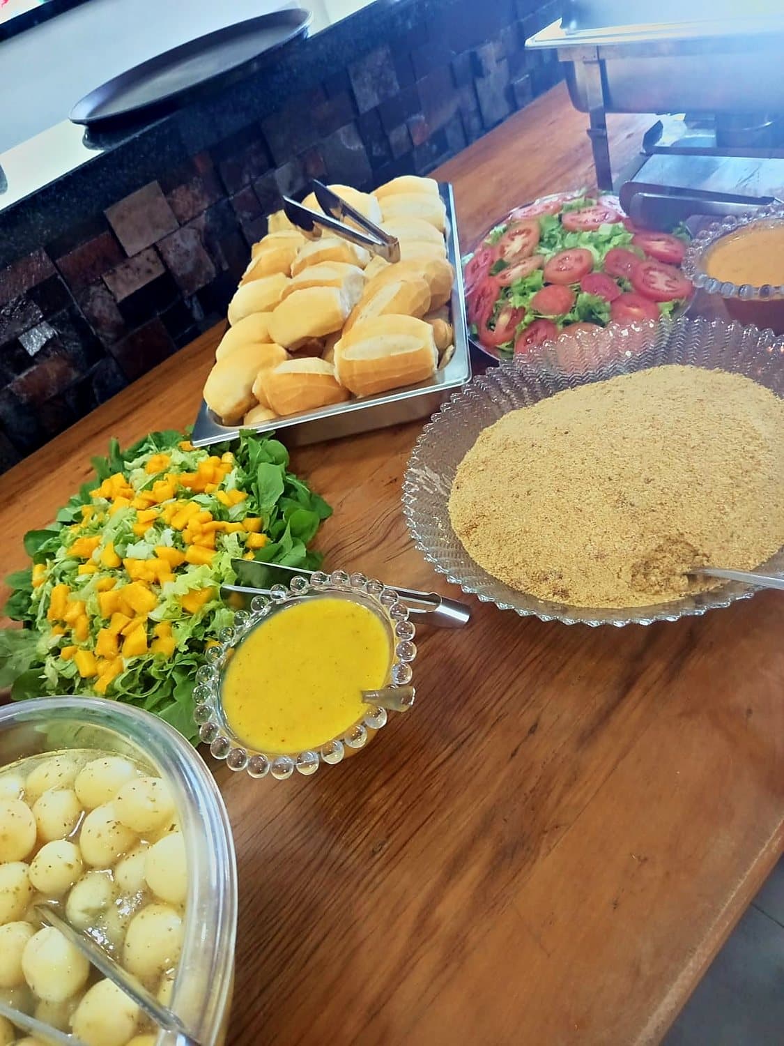 Mesa de buffet montada com entradas e acompanhamentos