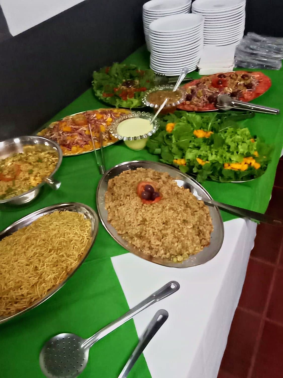Mesa de buffet com toalha verde e branca