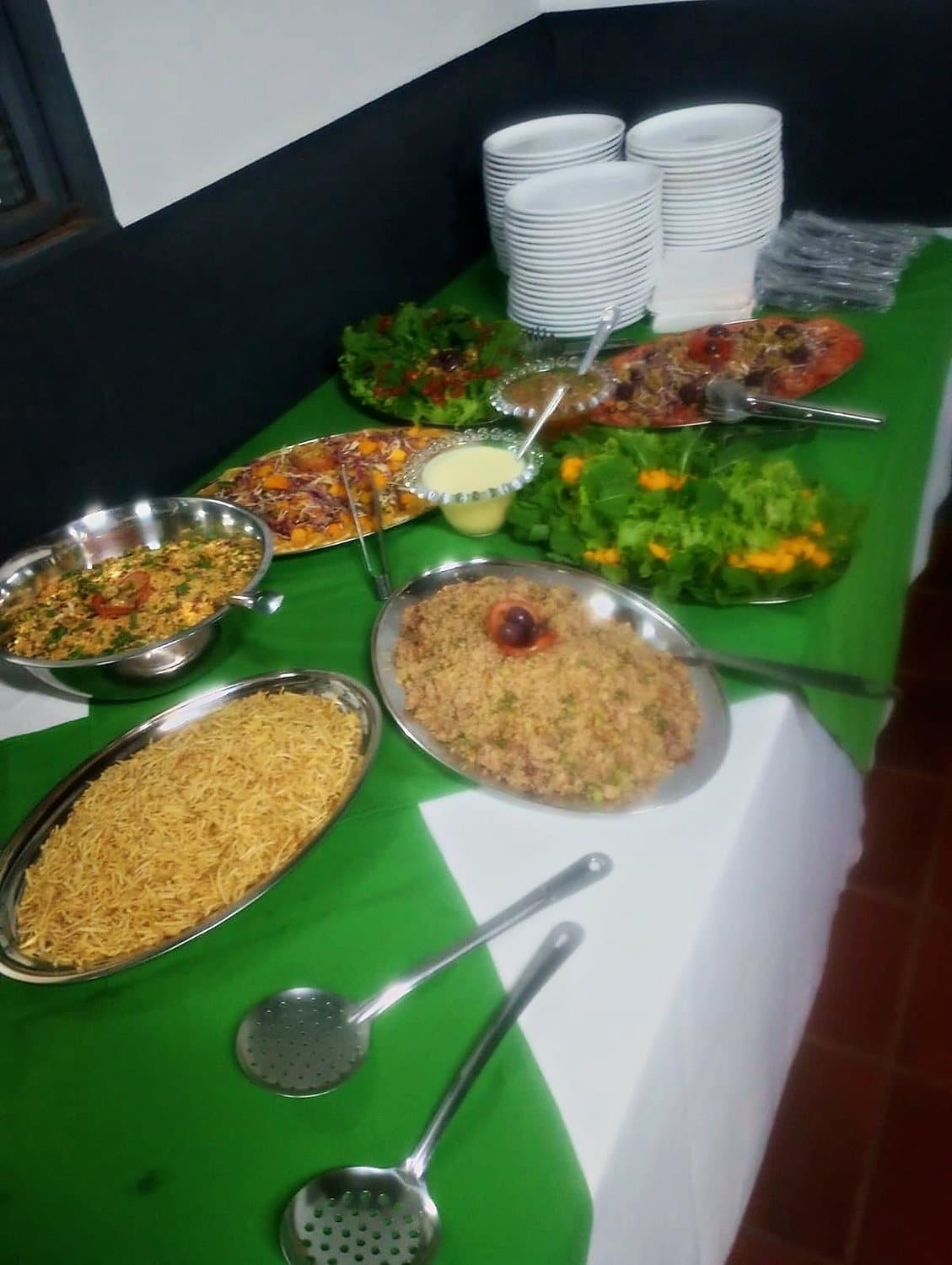 Travessas de arroz, farofa e saladas servidas