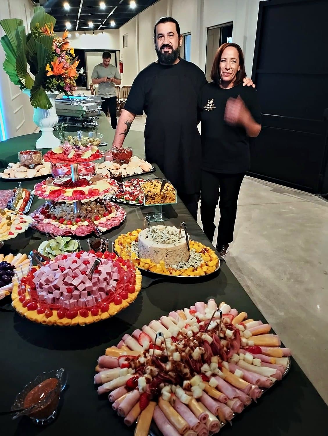 Equipe do AS Buffet ao lado da mesa de frios montada