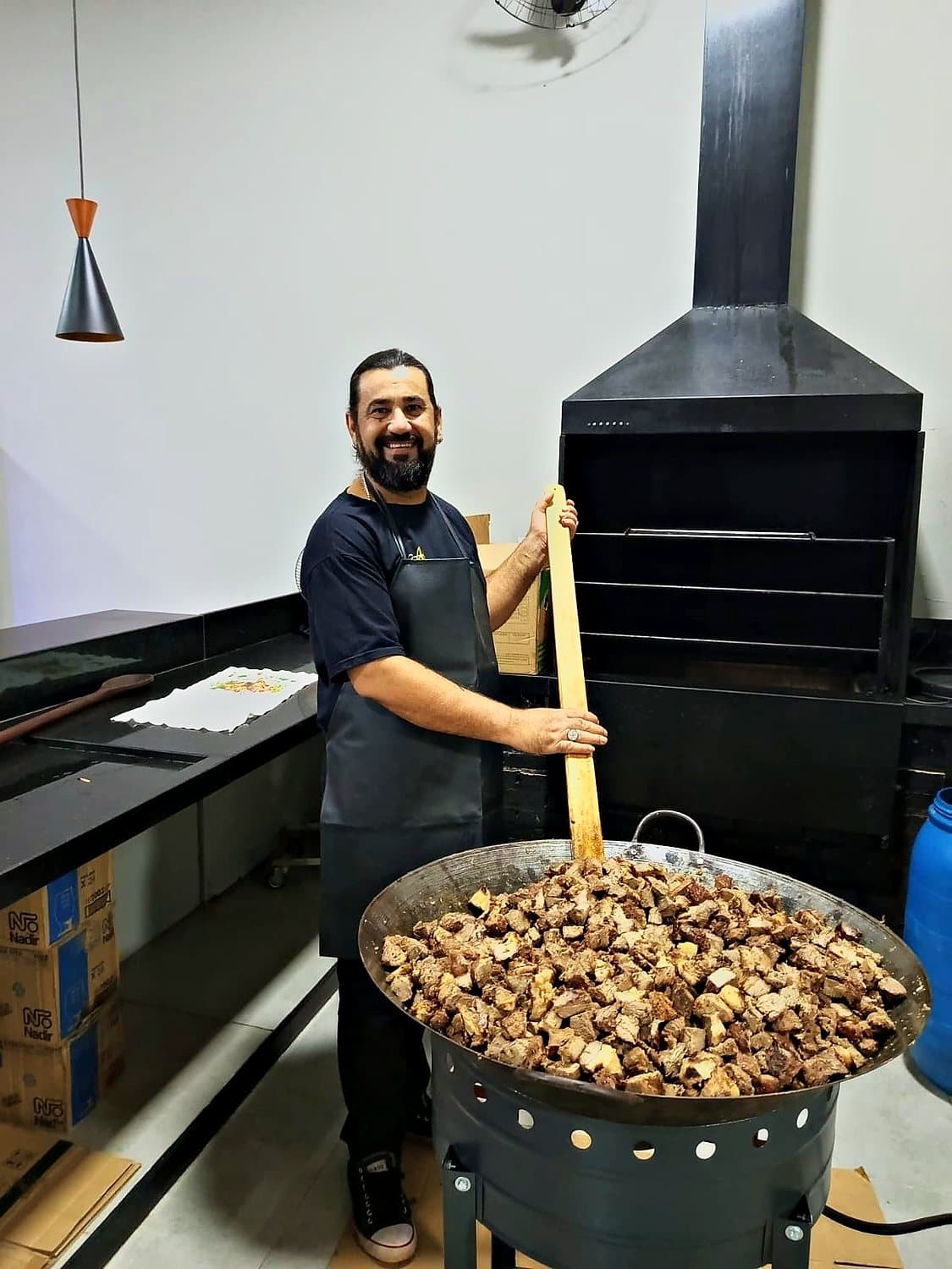 Cozinheiro mexendo a carne no tacho