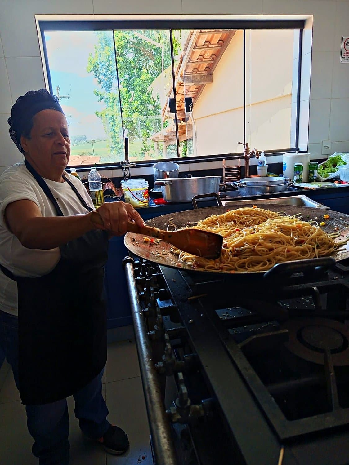Cozinheira finalizando o arroz no fogão