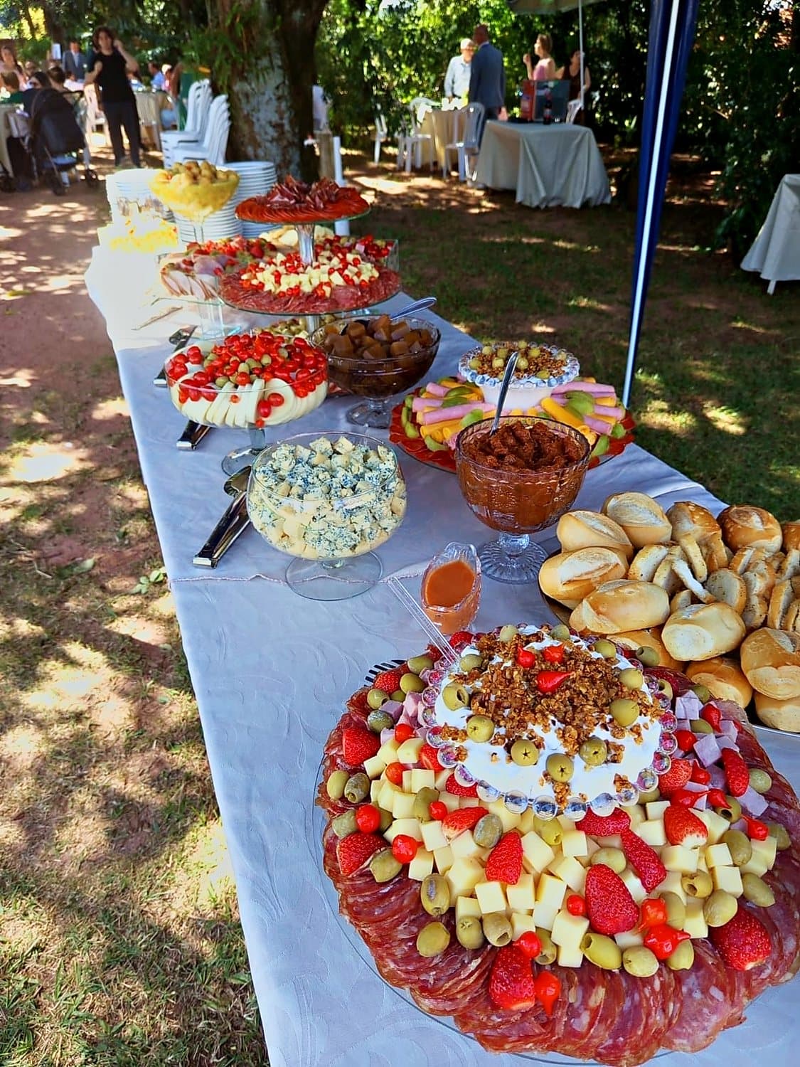 Mesa de buffet montada ao ar livre, sob as árvores